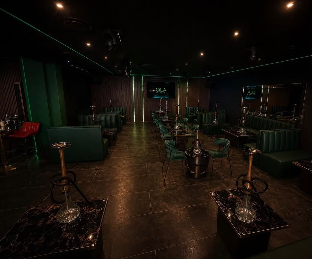 La sala reale di Ola, con sedute verde scuro e tavoli con narghilè